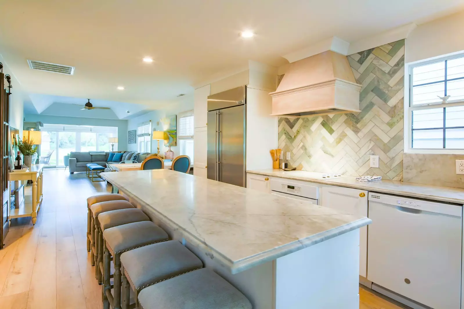 The kitchen features a built-in, stainless steel refrigerator and a hood over the range.