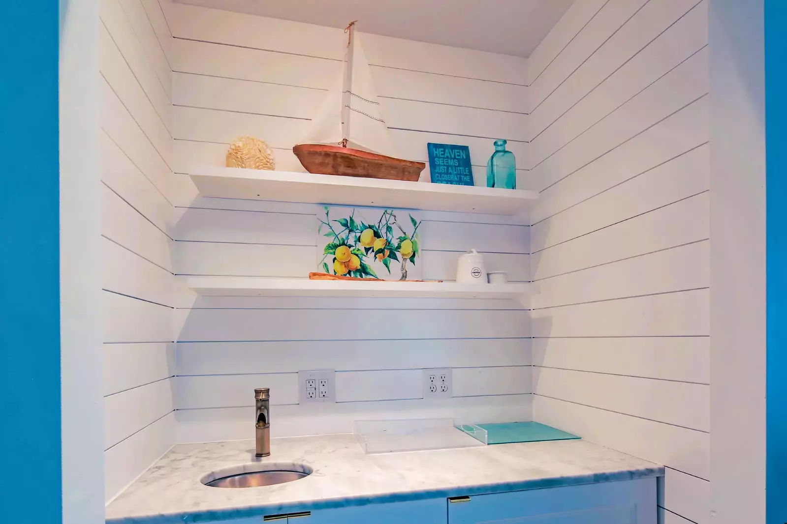 The living room also features a shiplapped mini bar area with sink.