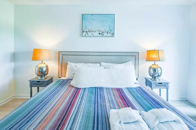 The master suite features a king bed and night stands with reading lamps.