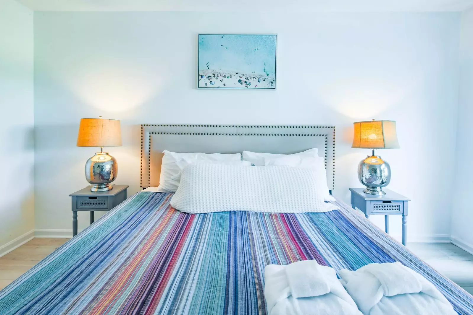 The master suite features a king bed and night stands with reading lamps.