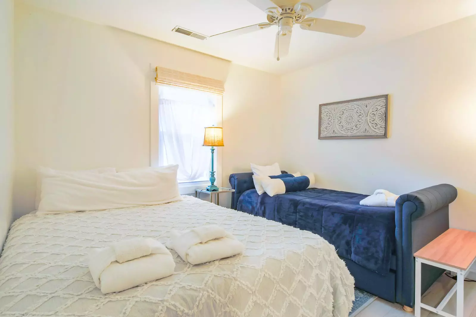 The guest bedroom features a queen bed, a twin day bed and a nightstand with reading lamp.