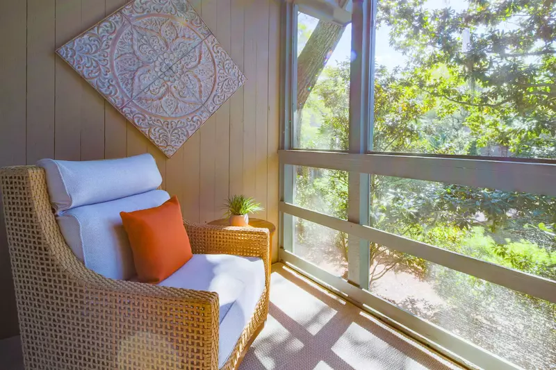 Palm Bungalow features a screened porch with relaxing forest views.