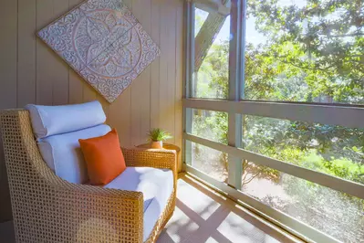 Palm Bungalow features a screened porch with relaxing forest views.