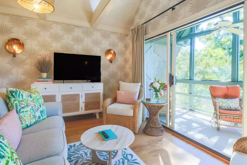 The living room seating area features two arm chairs, a sofa and large screen TV.