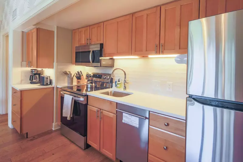 The kitchen features stainless steel appliances and a tiled backsplash.