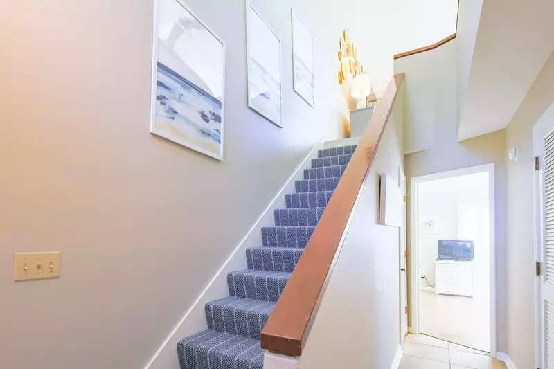 Take this interior staircase to access the living room, dining area, kitchen and screened porch.