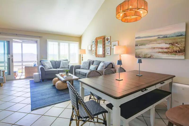 The living room & dining area features marsh views, a vaulted ceiling and access to the screened porch.