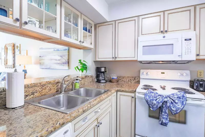 The kitchen features white cabinetry and granite countertops.
