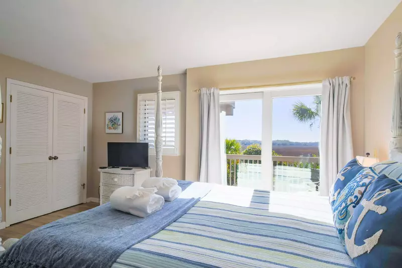 The master suite features marsh views, sliding door access to a private back porch and a TV.