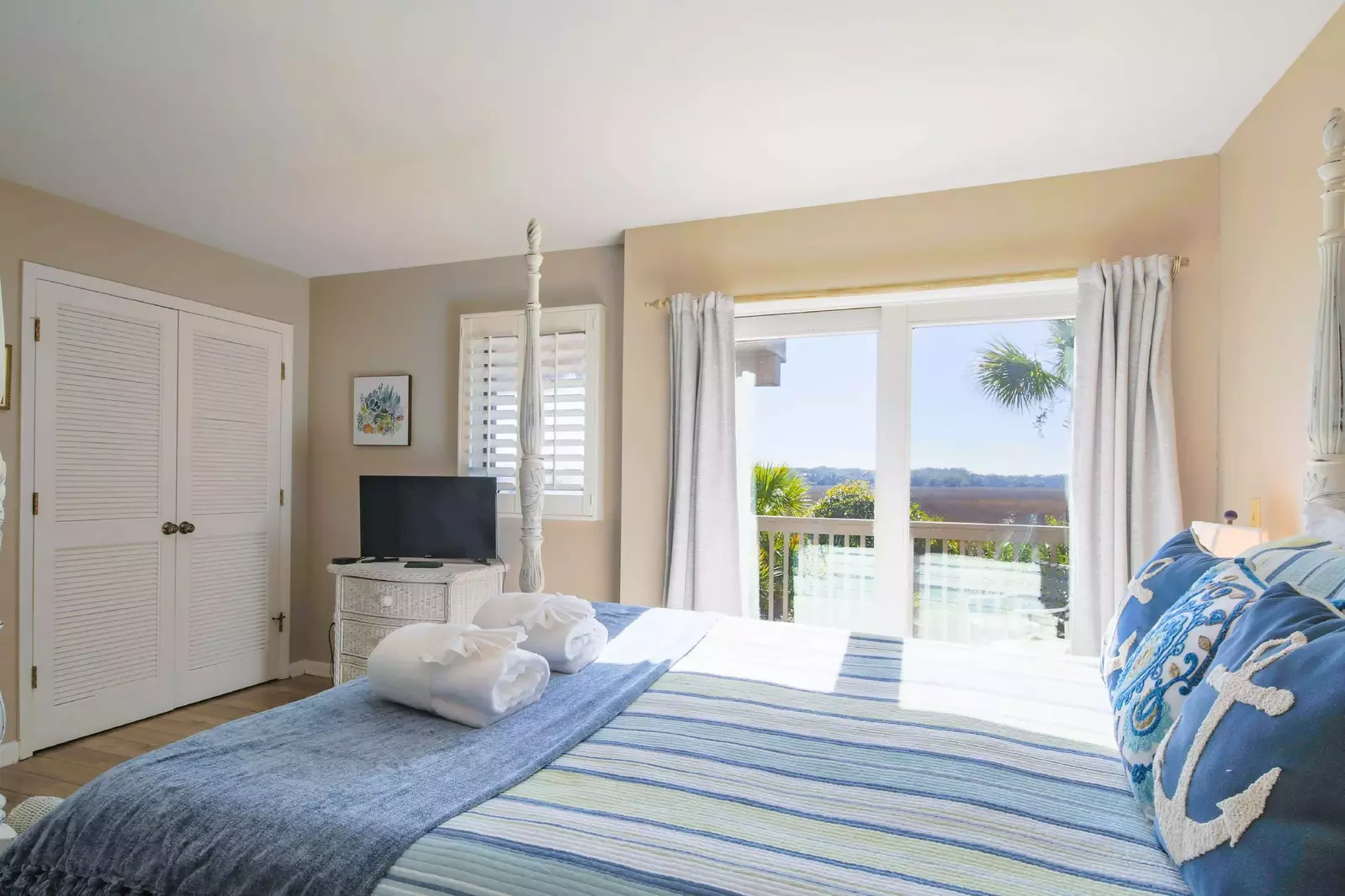 The master suite features marsh views, sliding door access to a private back porch and a TV.