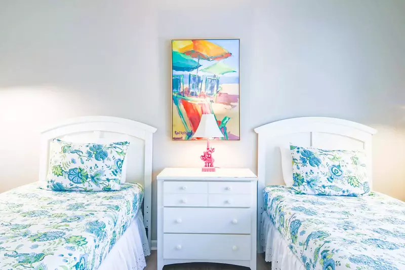 The guest suite features two twin beds and a night stand with a reading lamp.
