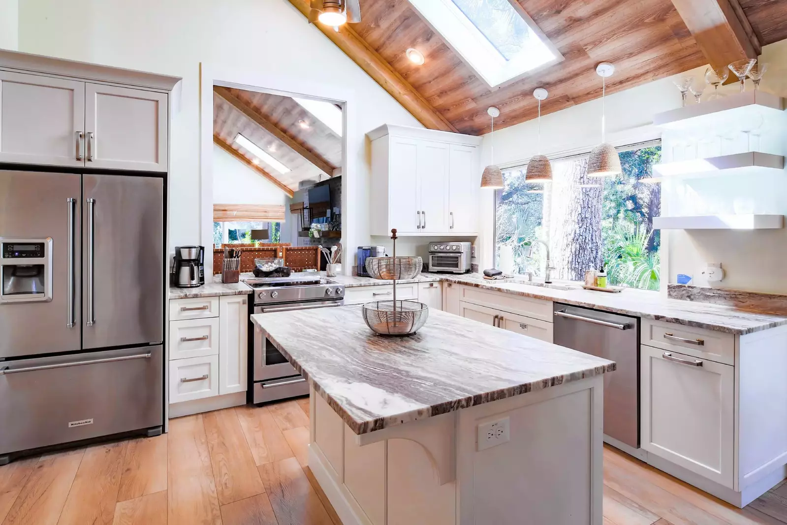 The kitchen features granite countertops, white cabinets and designer lighting fixtures.