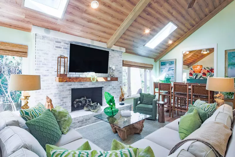 The living room features vaulted, wood-paneled ceilings and an expansive seating area.