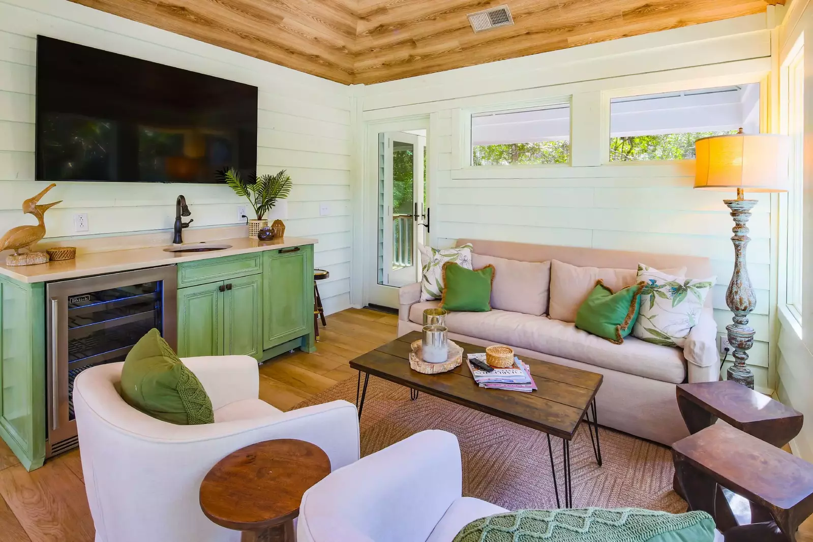 The sunroom also features a wall-mounted TV, mini bar and access to the screened porch.