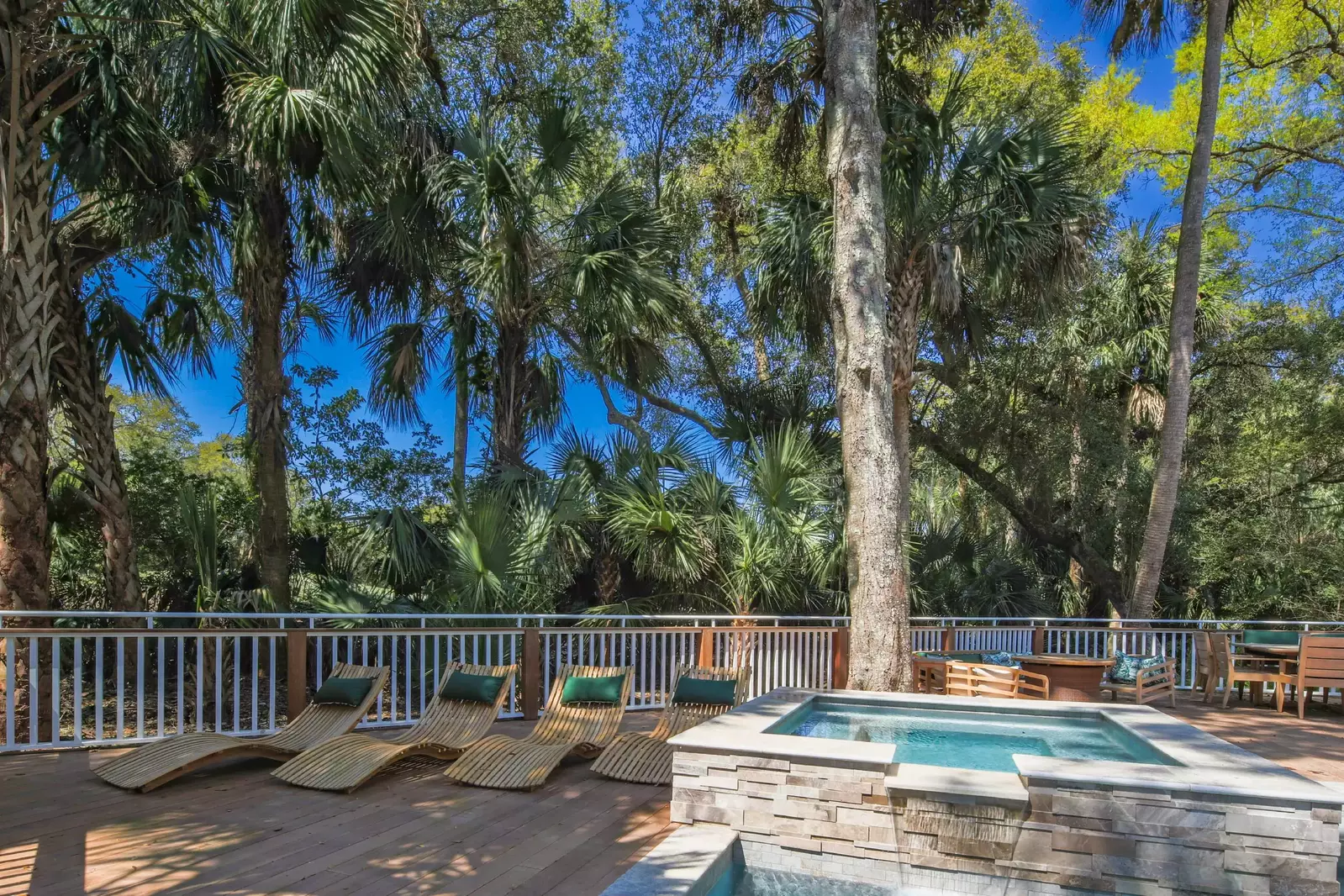 The back deck features a private pool, hot tub, sun loungers, seating area and outdoor dining table.