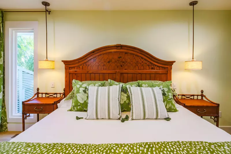 The master suite also features night stands and pendant lights.