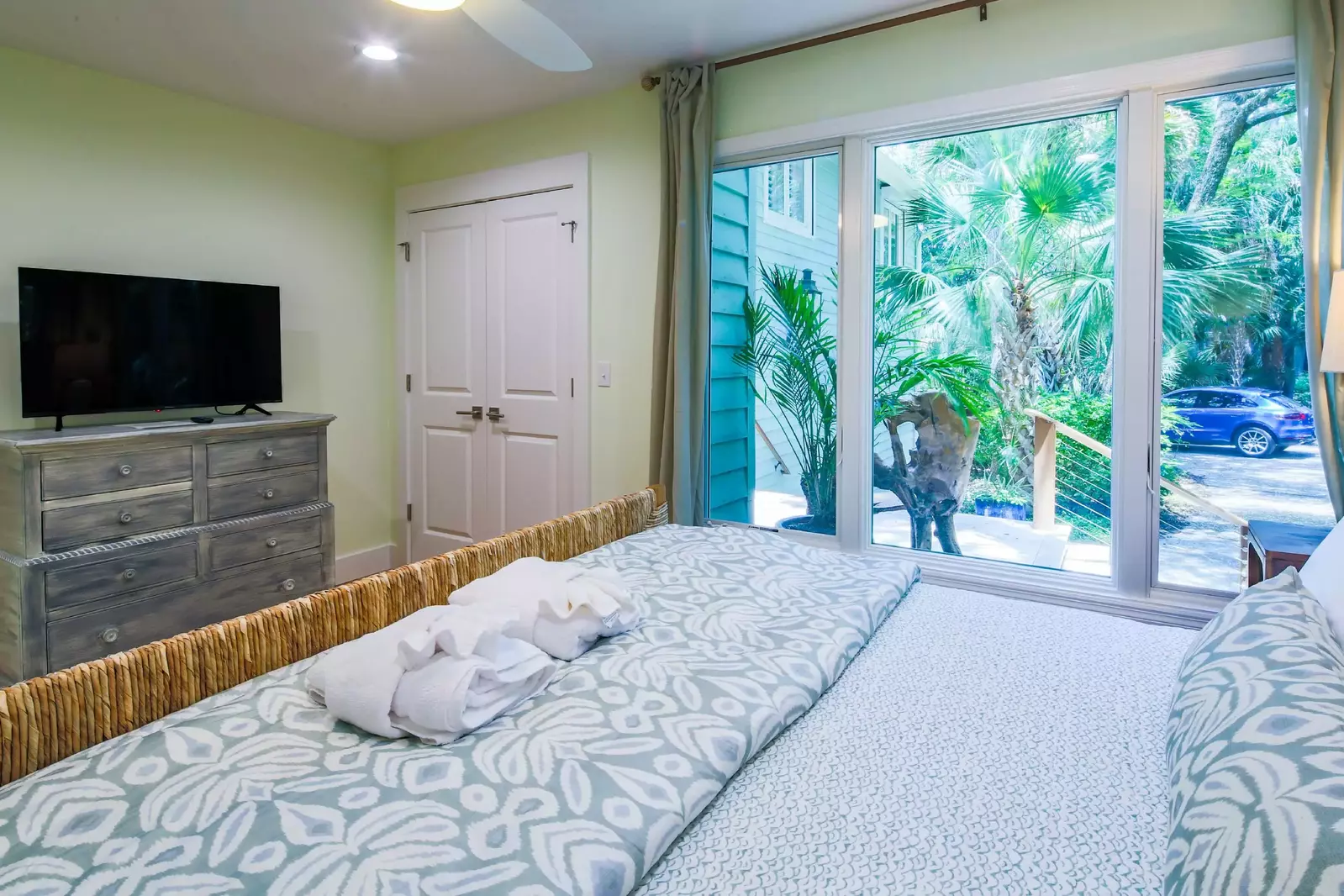 This king suite features a dresser, flat screen TV and large windows that look out the front of the home.
