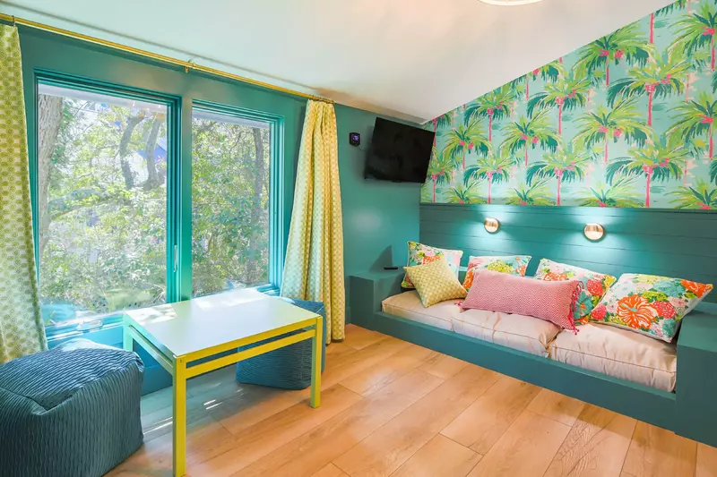 The bunk bedroom features three twin beds and this seating area.