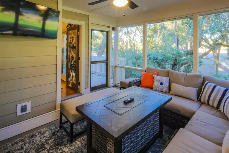There is also a wall-mounted smart TV and bench on the screened porch.