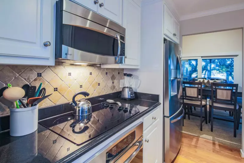 The kitchen also features an electric cooktop, oven, microwave and refrigerator.