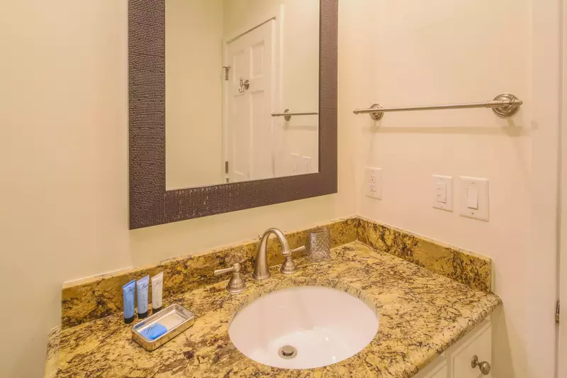 The primary bathroom features a spacious vanity with granite countertops.