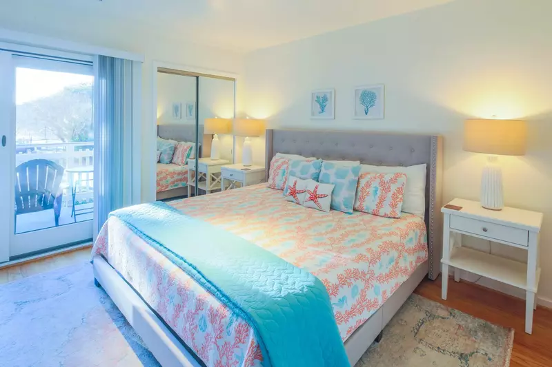 This guest suite features a king bed, night stands with reading lamps and access to the front porch.