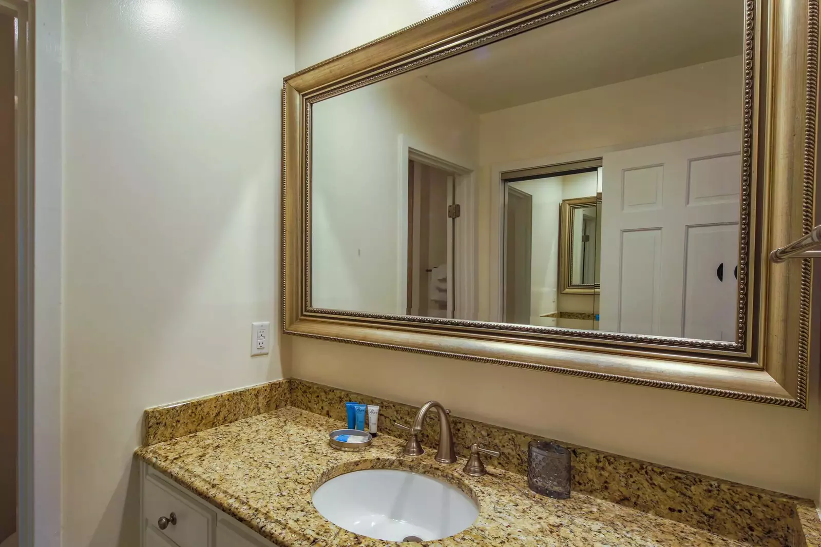 This bathroom features a spacious vanity with granite countertops.