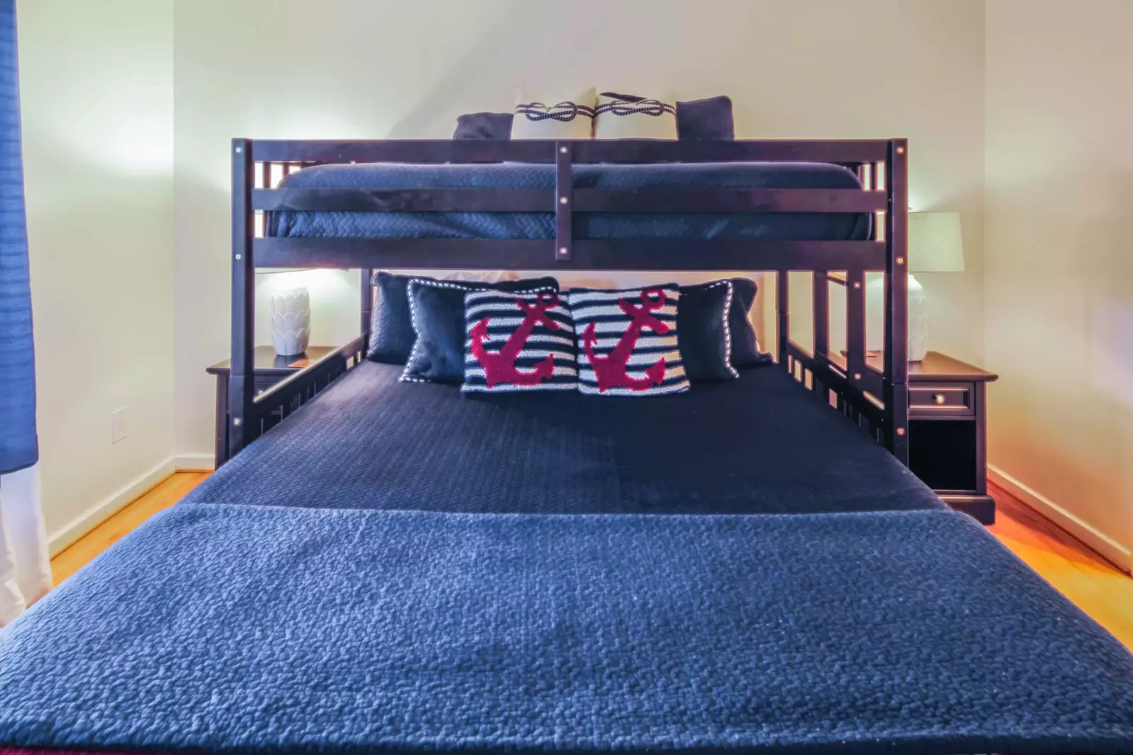 This guest suite features a bunk bed with a king bed on the bottom and a twin bed on the top bunk.