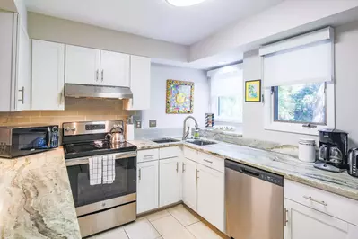 The kitchen features stainless steel appliances and white cabinets.