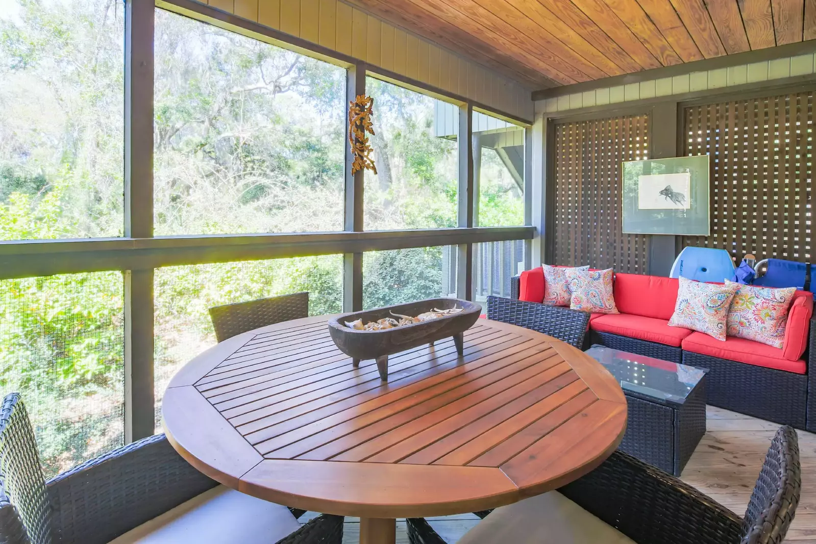 The screened porch features an outdoor dining table and a comfortable sectional.