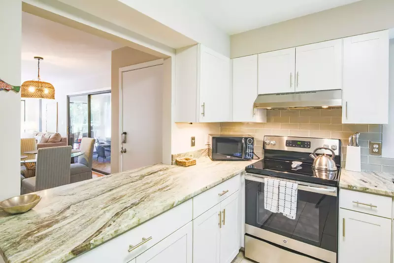 The kitchen features a tiled backsplash, granite countertops & stainless steel appliances.