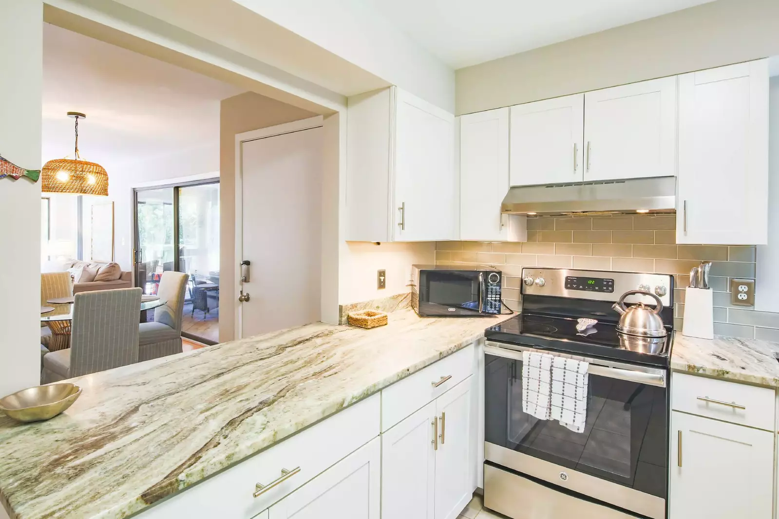 The kitchen features a tiled backsplash, granite countertops & stainless steel appliances.