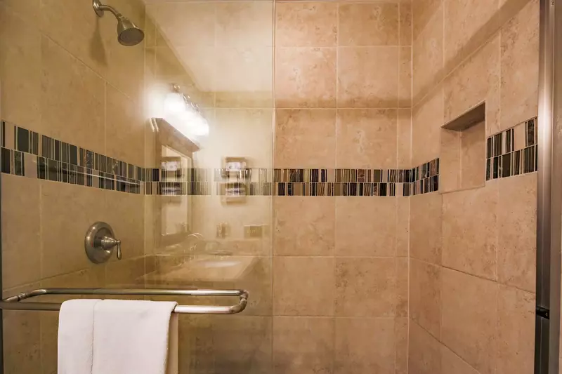 The en suite bathroom also features a beautifully tiled, walk-in shower.