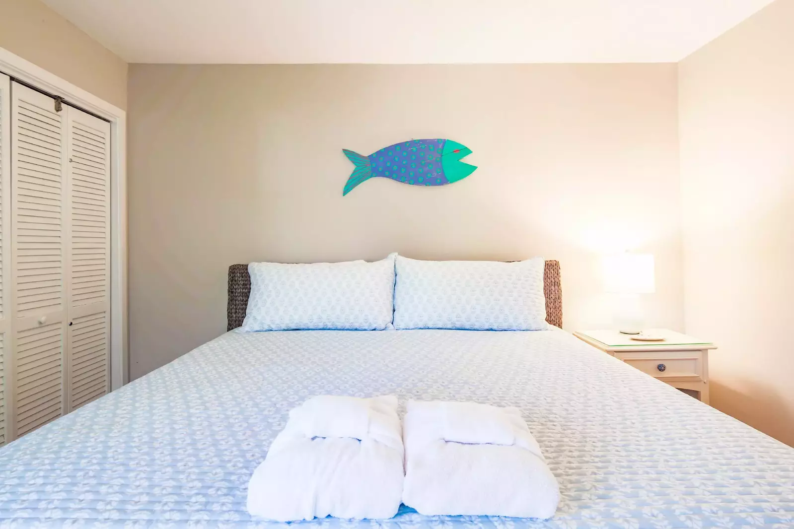 The guest bedroom features a king bed and night stand with reading lamp.