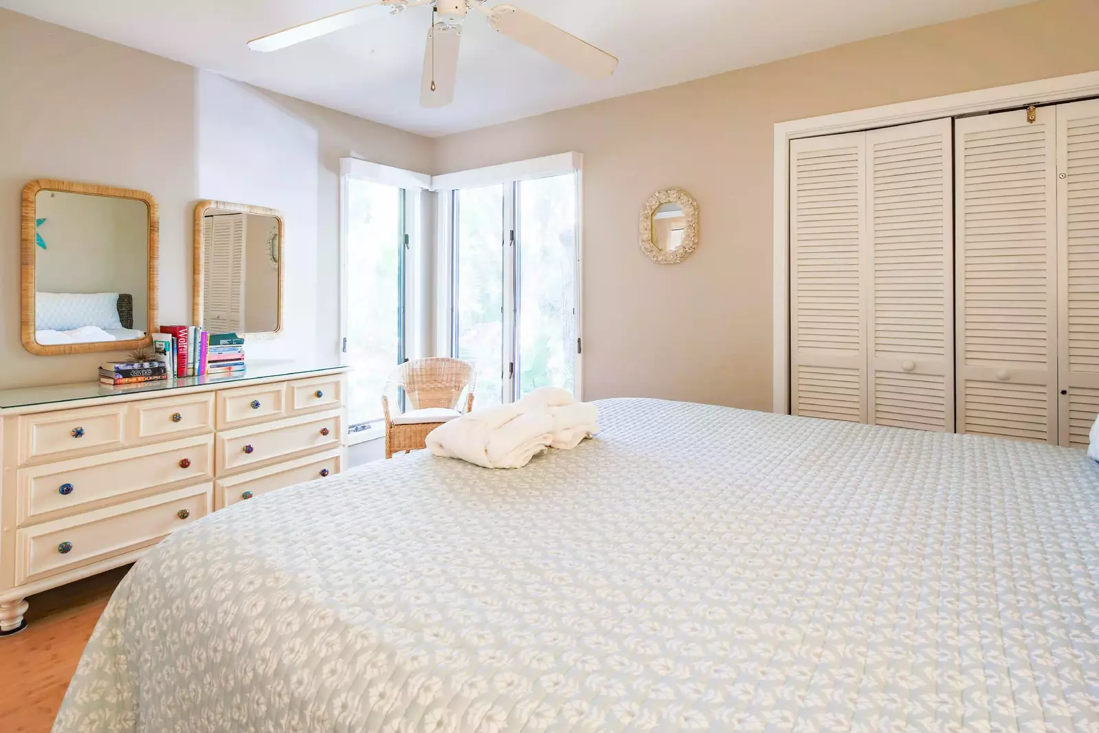 The guest bedroom also has a dresser, arm chair and ceiling fan