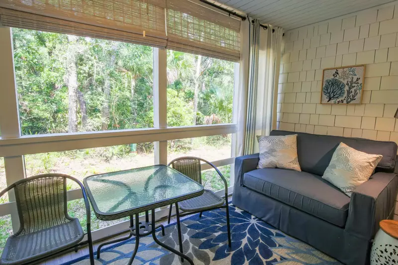 Sapphire Seascape features a screened porch with a dining table, loveseat and half bathroom.