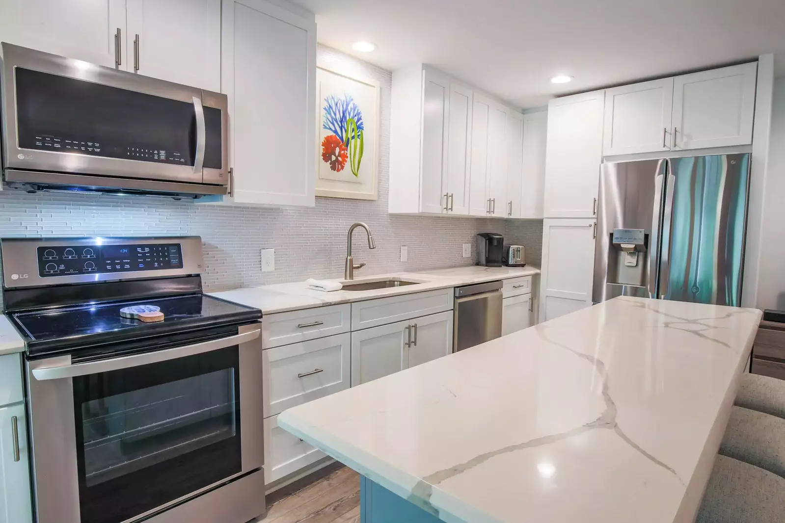 This gorgeous kitchen features stainless steel appliances, quartz counters and a central island with 4 stools.