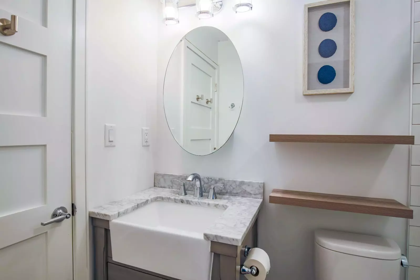 The renovated bathroom features a modern vanity and floating shelves.