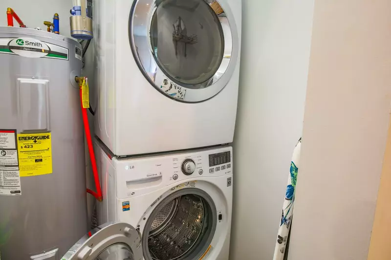 There is a stacked washing machine and dryer within the home.