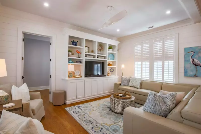 The living room features a spacious seating area, shiplap walls and a smart TV.