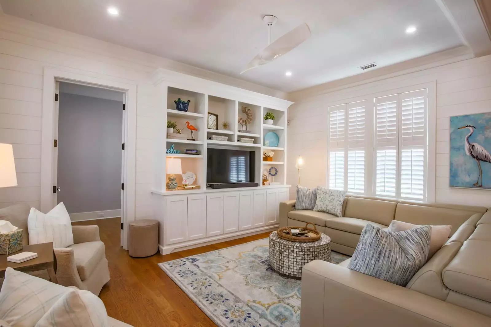 The living room features a spacious seating area, shiplap walls and a smart TV.