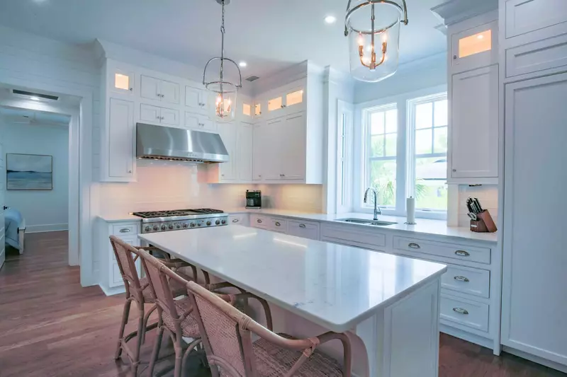 The kitchen features a center island, custom cabinetry, high end appliances and a tiled backsplash.