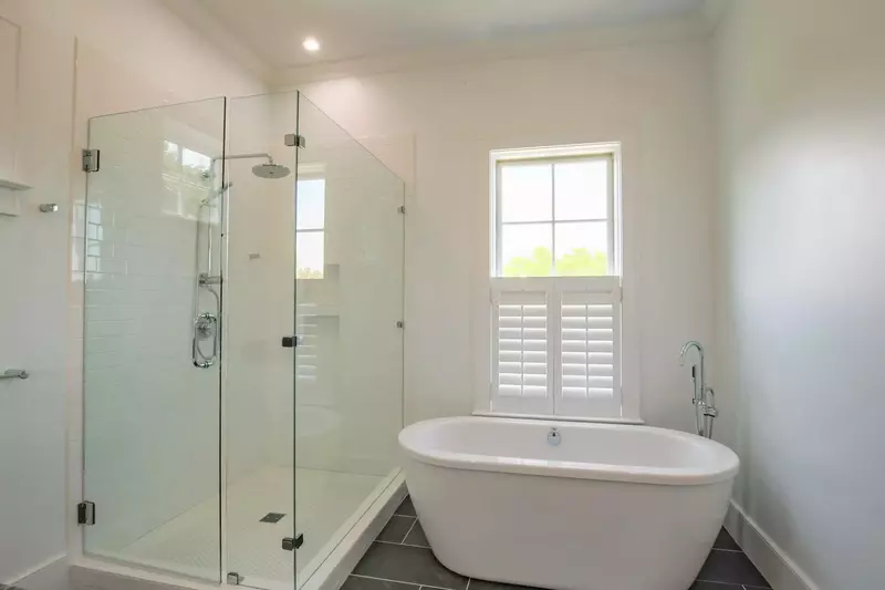 This en suite bathroom also boasts a tiled, walk-in shower and a separate soaking tub.