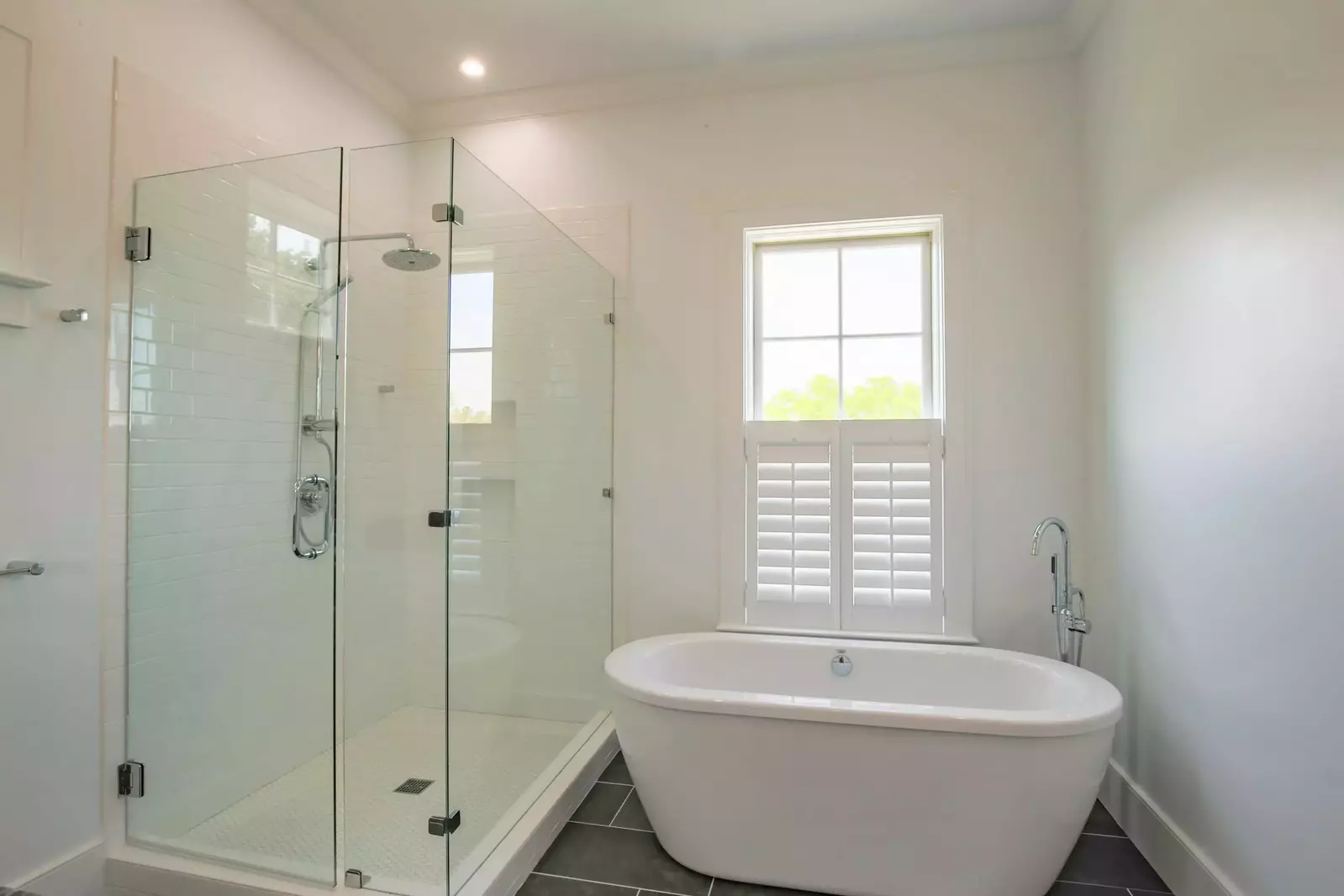 This en suite bathroom also boasts a tiled, walk-in shower and a separate soaking tub.