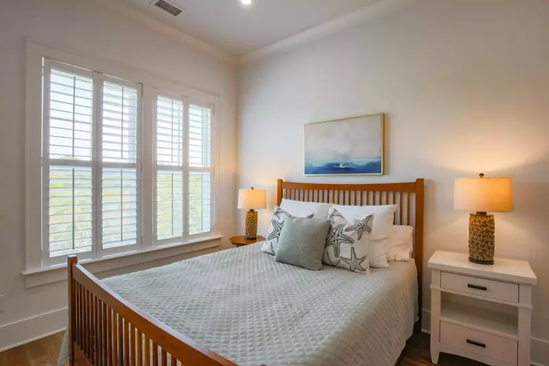 This guest bedroom, located on the home's upper level, features a queen bed and night stands with reading lamps.