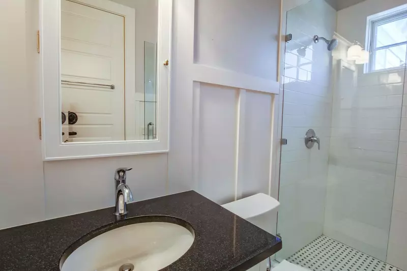 This en suite bathroom features a tiled, walk-in shower and a spacious vanity.