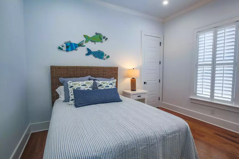 This guest bedroom features a queen bed and a night stand with a reading lamp.
