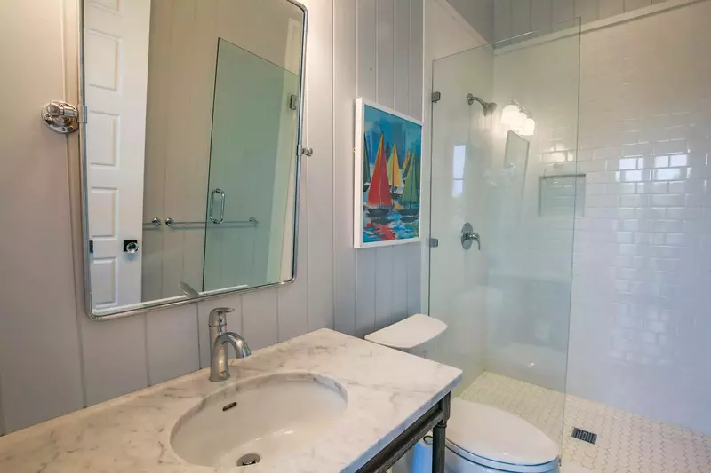 This hallway bathroom, with a tiled, walk-in shower, is shared by the bunk bedroom and queen guest bedroom.