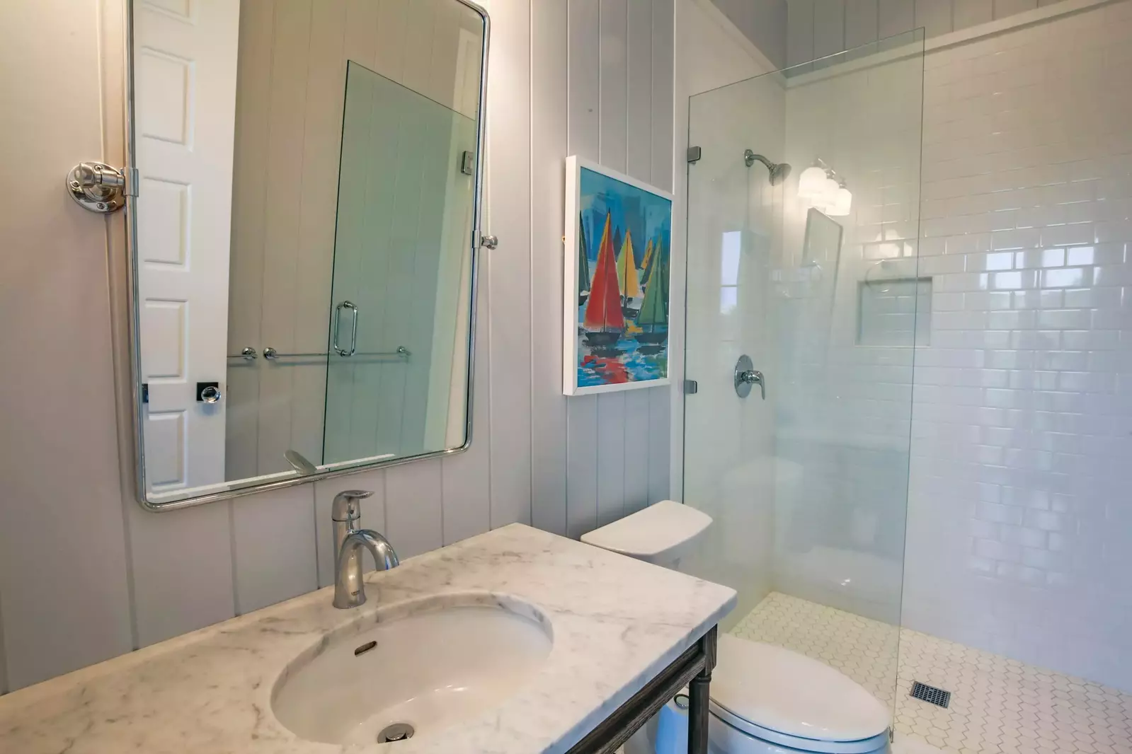 This hallway bathroom, with a tiled, walk-in shower, is shared by the bunk bedroom and queen guest bedroom.