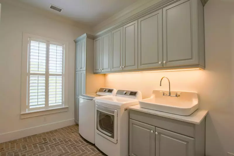Even the laundry room is spacious and gorgeous with its brick flooring, large utility sink and custom cabinetry.